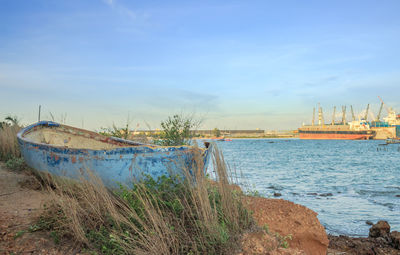 Boat moored on beach against sky