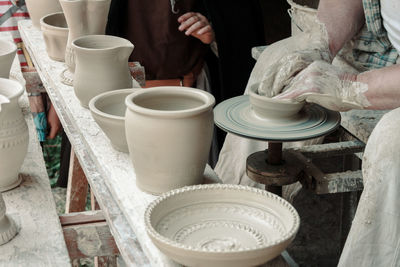 Midsection of man making clay bowl at workshop