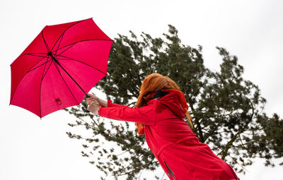 Low angle view of hand holding umbrella