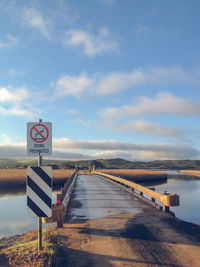 Road sign against sky