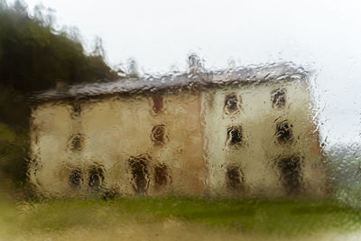 Close-up of wet glass window during rainy season
