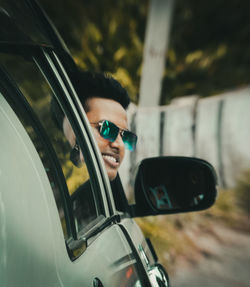 Smiling man looking through car window