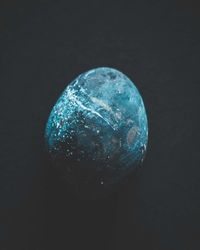 Close-up of blue glass against black background