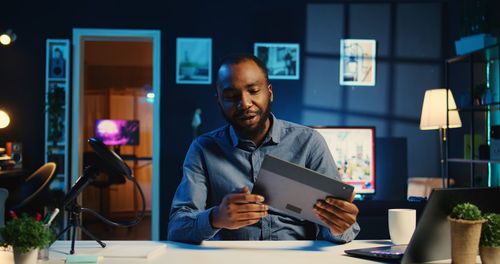 Young man using laptop while sitting on table