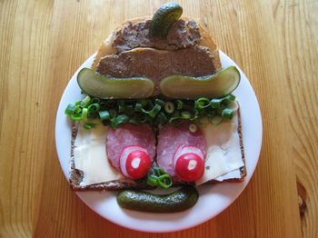 High angle view of anthropomorphic face made from bread and vegetables