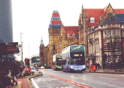 Cars on street in city against sky