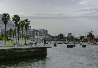 Scenic view of river by buildings against sky