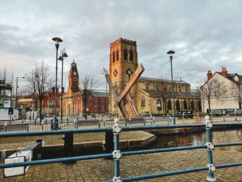 Canal by buildings against sky