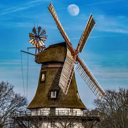 Low angle view of traditional windmill against sky