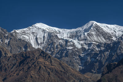 Scenic view of snowcapped mountains against clear blue sky