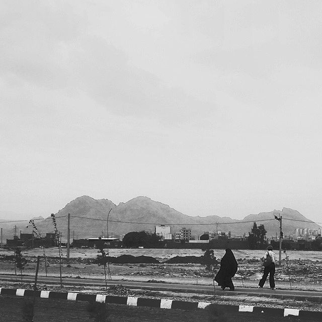 transportation, mountain, sky, built structure, large group of people, copy space, water, person, architecture, lifestyles, men, sea, clear sky, leisure activity, building exterior, road, incidental people, railing, day