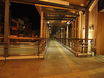 Illuminated footbridge by building in city