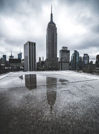 City at waterfront against cloudy sky