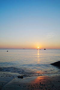 Scenic view of sea against clear sky during sunset