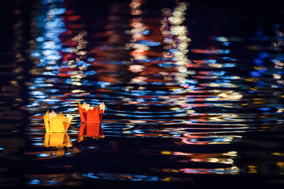 Paper boats in lake at night