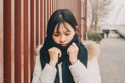 Young woman wearing warm clothing in city during winter