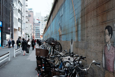 People walking on road along built structures