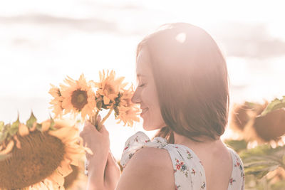 Portrait of beautiful woman by flowering plants