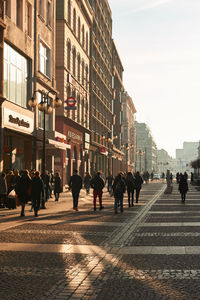 People walking on road along buildings