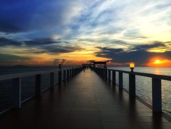 Pier over sea against sky during sunset