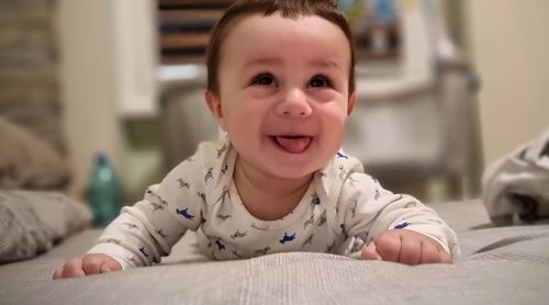 Portrait of cute baby on bed at home
