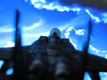 Low angle view of hand against blue sky