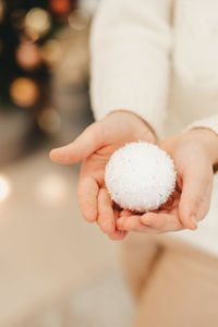 White christmas tree toy close-up, in the hands of a girl. vertical frame