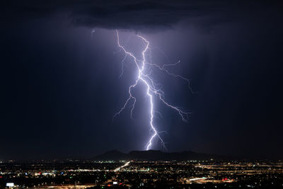 A powerful lightning bolt strikes from a monsoon thunderstorm over phoenix, arizona.