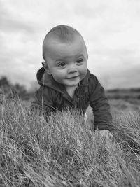 Portrait of boy on field against sky