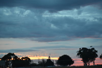 Silhouette of trees against dramatic sky