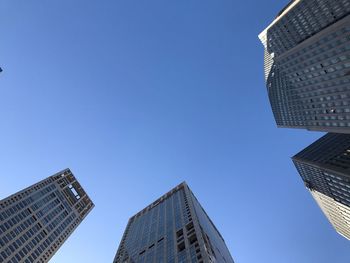 Low angle view of skyscrapers against blue sky