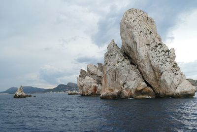 Scenic view of rock formation in sea against sky