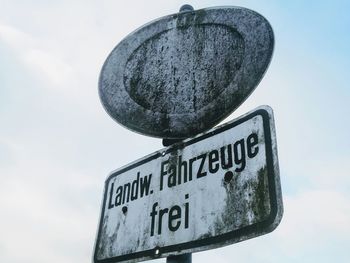 Low angle view of signboard against sky