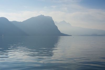 Scenic view of sea and mountains against sky