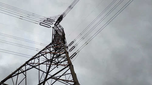 Low angle view of electricity pylon against sky