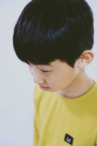 Close-up of cute boy standing against white background