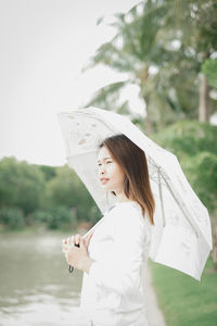 Side view of woman standing against the sea