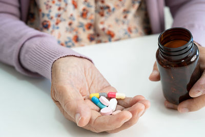 Midsection of woman holding pills