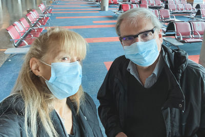 Portrait of senior couple wearing mask standing outdoors