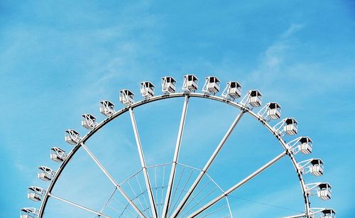 Low angle view of ferris wheel against blue sky