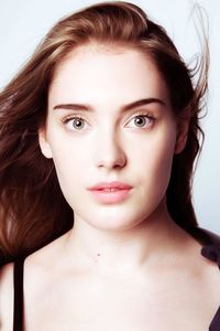 Close-up portrait of beautiful young woman against white background