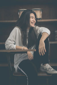 Smiling young woman sitting on chair