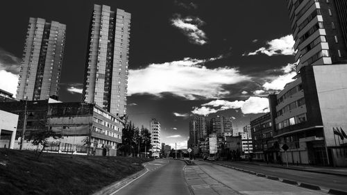 View of city street against cloudy sky