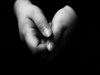 Cropped image of hands against black background