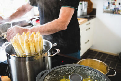 Midsection of man preparing food in kitchen