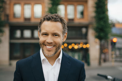 Portrait of smiling businessman in city