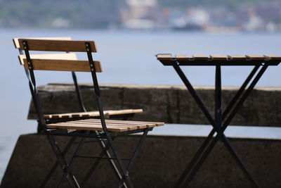 Close-up of empty chairs and table at sidewalk cafe