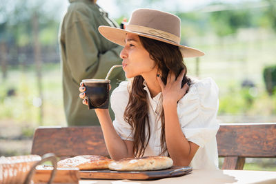 Midsection of woman sitting on table