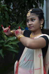 A teenage girl practicing bharatnatyam in nature