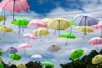 Low angle view of umbrellas hanging against sky